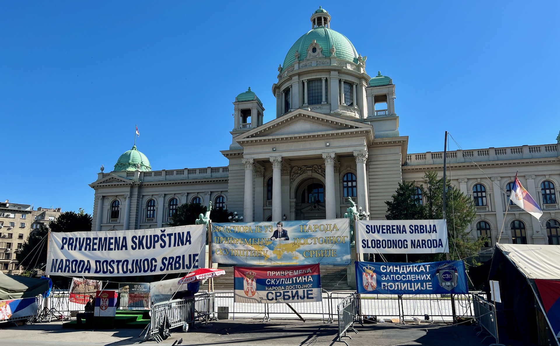 Protest outside of a civic building. The text here translates to “Provisional Assembly of the Dignified People of Serbia.”